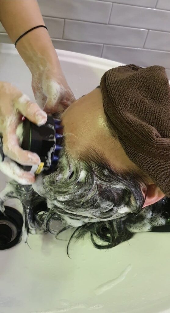 새치염색 후 두피자극을 줄이기 위해 미지근한 물로 샴푸하는 모습